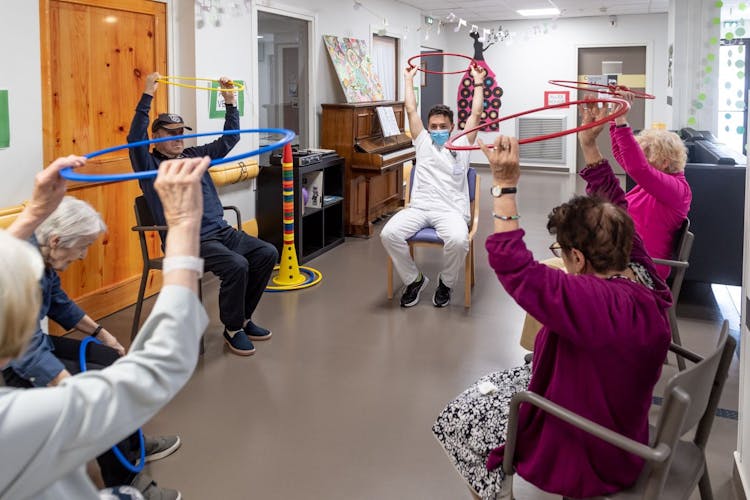 Photo illustrant un groupe de patients réalisant des exercices de motricité grâce à des cerceaux et guidé par un réeducateur de la clinique des minimes